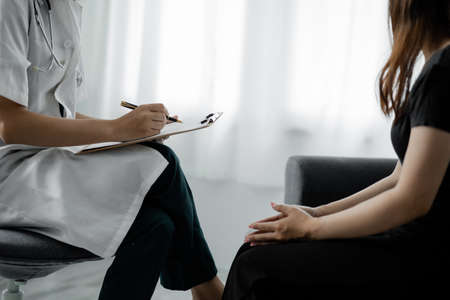 An examination room atmosphere in a hospital where doctors and patients are examining and diagnosing and prescribing medications for symptomatic treatment. The concept of disease diagnosis.の写真素材