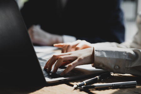Close-up of hands resting on keyboard to view financial data, business growth in the world of cryptocurrencies and the current global economy with war and volatility. Finance and investment concepts.の写真素材
