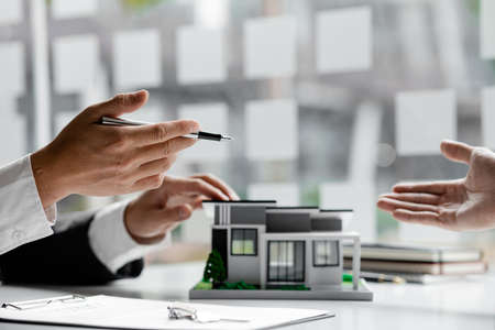 Real estate agents explain models of housing estates in projects to elaborate to clients, explaining and presenting information about homes and purchasing loans. Real estate trading concept.の写真素材