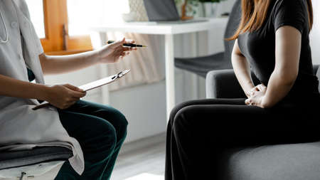 An examination room atmosphere in a hospital where doctors and patients are examining and diagnosing and prescribing medications for symptomatic treatment. The concept of disease diagnosis.の写真素材
