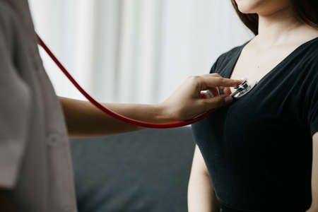 A female doctor using a stethoscope, she is examining the patient in the examination room and informing the patients about treatment guidelines and prescribing medicines. Disease examination concept.の写真素材