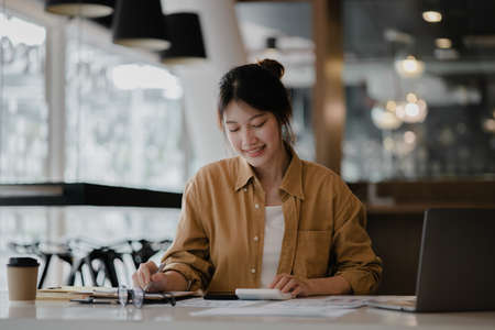 Beautiful Asian woman is a businesswoman who leads a new generation of startups, a woman who runs and manages a business plan to build confidence and stability in business, woman-led business concept.の写真素材