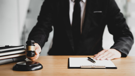 A person holding the hammer of justice, the concept of a lawyer or a law enforcement officer is...