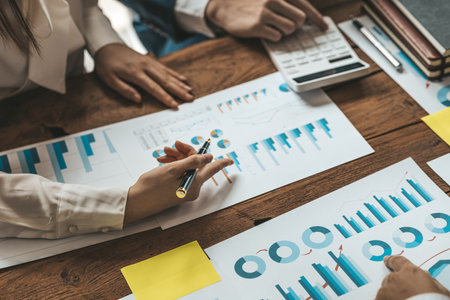 A desk in a company conference room has a group of business people attending and with supporting documents laid out, brainstorming sessions to fix and plan the company's growth. Business meeting idea.の写真素材
