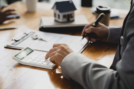 Rental company employee is discussing the details before the customer agrees to sign a rental contract, explaining the details and the terms and conditions of the rental. Real estate rental ideas.の写真素材