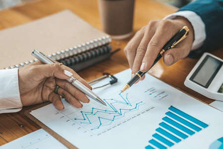 Two Asian business women are meeting to summarize the company's operating, financial, profit and...