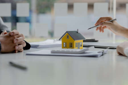 Real estate agents explain models of housing estates in projects to elaborate to clients, explaining...