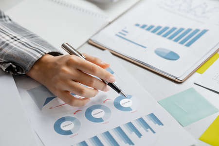 Business women are looking at the company's financial documents to analyze problems and find solutions before bringing the information to a meeting with a partner. Financial concept.の写真素材