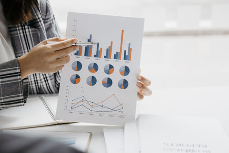 Business women are looking at the company's financial documents to analyze problems and find...