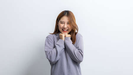 Portrait of beautiful Asian woman doing cheerful pose on isolated yellow background, portrait...