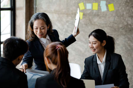 A highly qualified senior businesswoman is having training meetings with the subordinate team, planning meetings and internal discussions. Management concepts of senior executives.の写真素材