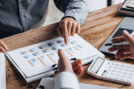 Two businessmen are reviewing monthly sales documents for analysis and marketing plans for more sales growth, they are the founders of young companies co-founding startups. Sales management concept.の写真素材