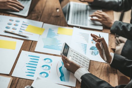 Person holding a white calculator to calculate numbers on company financial documents, a financial...