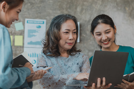A startup executive is meeting with a new generation of employees to plan and discuss, she is an experienced senior executive with a modern mindset. Management concept of startup company.の写真素材