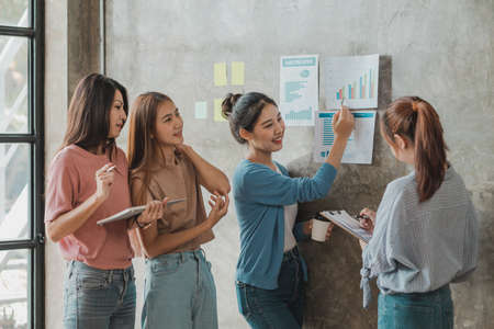 A group of young Asian business women stand and talk. Jointly open a startup company and a business...