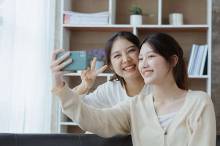 Two beautiful Asian women in a homosexual relationship, queer, gay couple, advocating sexual independence and pride in LGBTQ. Lgbt and love relationship. Supporters of the LGBT community.の写真素材