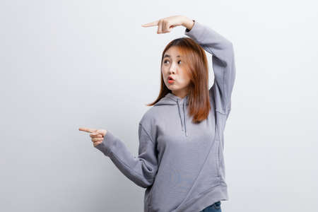 Beautiful Asian woman gesturing for advertisement editing on isolated background, portrait concept used for advertisement and signage, isolated over white background, copy space.の写真素材