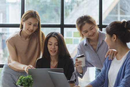 A group of young Asian business women stand and talk. Jointly open a startup company and a business...