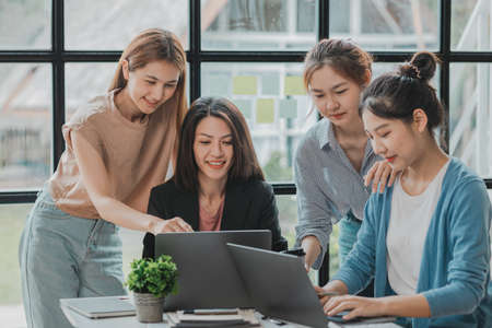 A group of young Asian business women stand and talk. Jointly open a startup company and a business plan management plan to grow the business and be profitable by the concept of the new generation.の写真素材