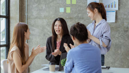 A group of young Asian business women stand and talk. Jointly open a startup company and a business plan management plan to grow the business and be profitable by the concept of the new generation.の写真素材
