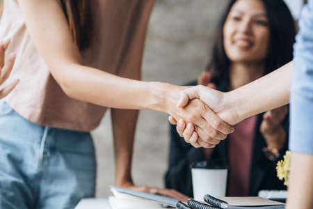 Close-up two business men holding hands, Two businessmen are agreeing on business together and shaking hands after a successful negotiation. Handshaking is a Western greeting or congratulation.の写真素材