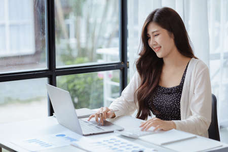 Asian women working in the office, young Asian business women as business executives, founding and running start-up executives, young female business leaders. Startup business concept.の写真素材