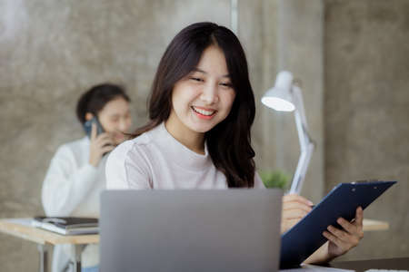 Asian women working in the office, young Asian business women as business executives, founding and running start-up executives, young female business leaders. Startup business concept.の写真素材