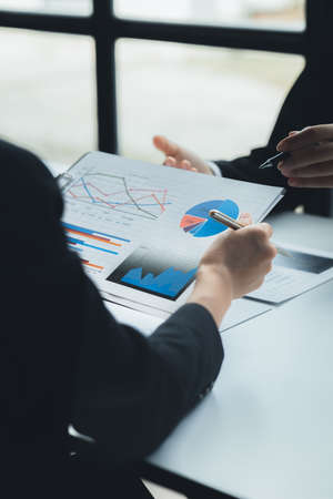 Two businessmen are reviewing monthly sales documents for analysis and marketing plans for more...