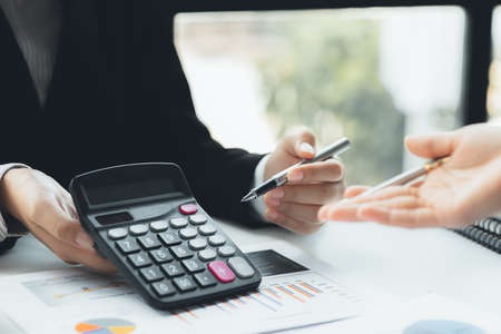A conference room where executives and marketers are looking at sales documents to analyze, plan...