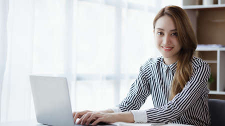 Beautiful Asian woman is a businesswoman who leads a new generation of startups, a woman who runs and manages a business plan to build confidence and stability in business, woman-led business concept.の写真素材