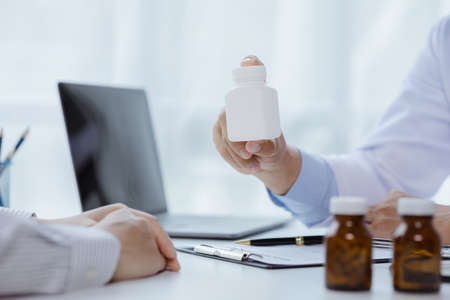 Doctors are giving advice on medication to patients in hospital examination rooms, treating diseases from specialists and providing targeted treatment. Concepts of medical treatment and specialists.の写真素材