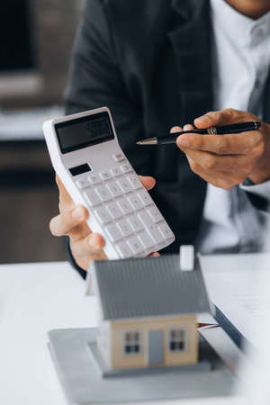 Rental company employee is discussing the details before the customer agrees to sign a rental contract, explaining the details and the terms and conditions of the rental. Real estate rental ideas.の写真素材