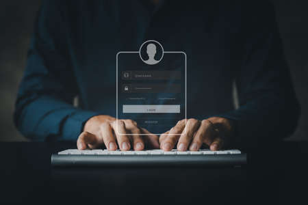 An individual is typing on a keyboard laptop showing a hologram interface to a member login, a...