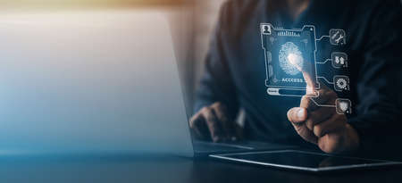Businessman with a laptop, hologram icon fingerprint encryption, protecting access to confidential information by using fingerprint technology. Fingerprint encryption concept.の写真素材
