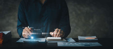 A businessman examines data on financial documents, company financial reports, graphics showing financial and numerical growth data. The concept of financial management to grow and be profitable.の写真素材