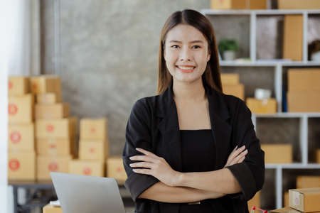 Woman owner of a startup company selling products online on an online store platform, sending goods through a courier company, Business planning. Online selling and online shopping concepts.の写真素材