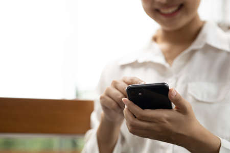 Asian woman using mobile phone, she surfs internet and social media on smartphone, chatting on app...