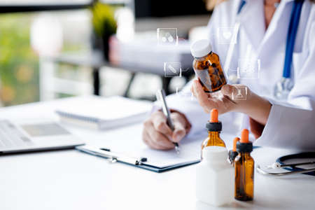 Physician holding a vial with medical icons, consulting patients and treating specialists, providing targeted treatment, medical concepts and specialists.の写真素材