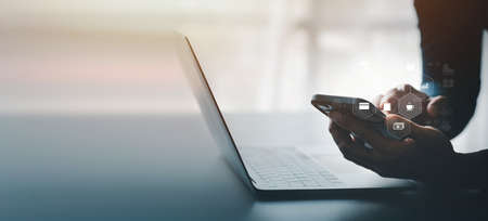 A person holding a phone with online shopping icons, ordering goods and services online on a...