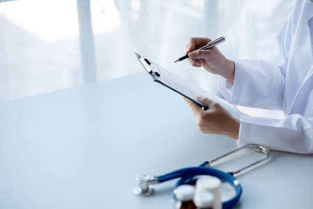 Doctors looking at patient's diagnostic documentation in the hospital's medical room, treating...