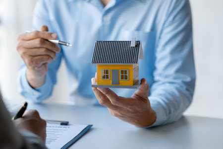 Rental company employee is discussing the details before the customer agrees to sign a rental contract, explaining the details and the terms and conditions of the rental. Real estate rental ideas.の写真素材