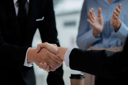 Business investor group holding hands, Two businessmen are agreeing on business together and shaking hands after a successful negotiation. Handshaking is a Western greeting or congratulation.の写真素材