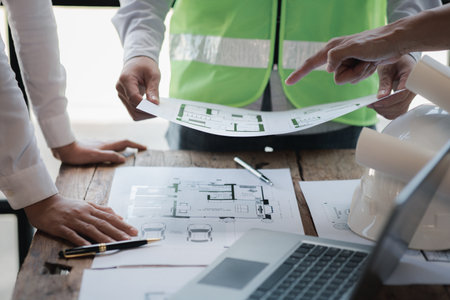 Architects and engineers are working together to edit the draft house plan that was designed after...