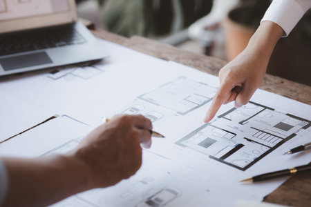 Two architects and engineers are in a meeting to discuss and inspect the house designs to meet the building and construction standards. Interior design and decoration ideas.の写真素材