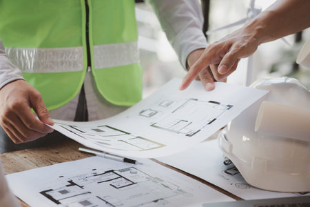 Architects and engineers are working together to edit the draft house plan that was designed after...