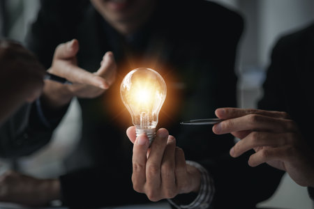 Businessman holds a glowing lamp, Creative new idea. Innovation, brainstorming, strategizing to make the business grow and be profitable. Concept execution, strategy planning and profit management.の写真素材