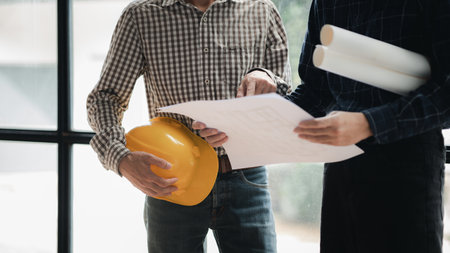 Two architects and engineers are in a meeting to discuss house designs according to building and...