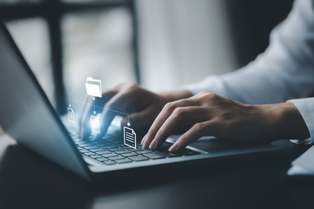 business man typing on a keyboard with holograms of digital document files, data files on computers...