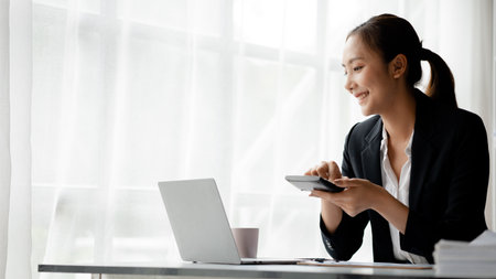 Asian women working in the office, young Asian business women as business executives, founding and running start-up executives, young female business leaders. Startup business concept.の写真素材
