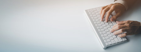 Person typing on a computer keyboard, businessman is working in a startup company's office, he is...